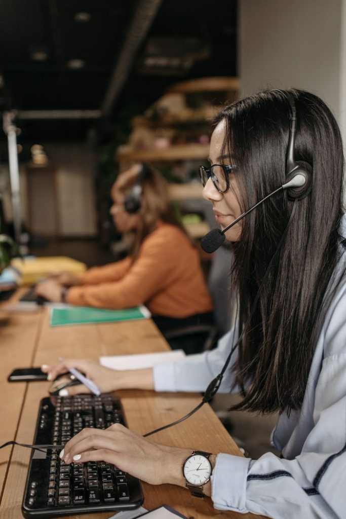 Side view of a female call center employee working diligently with a headset.